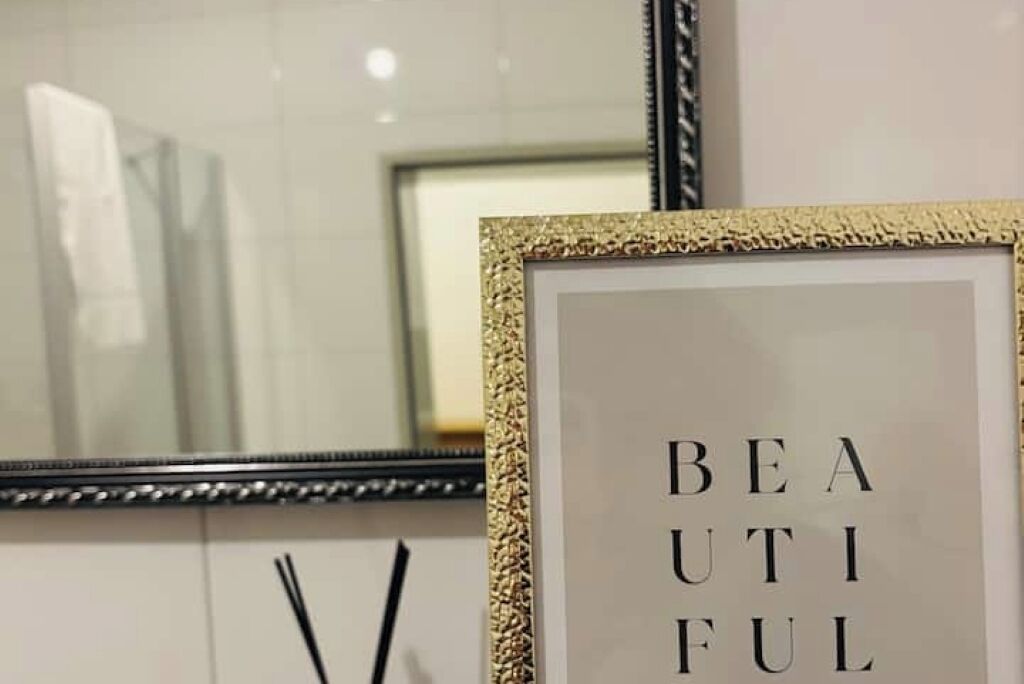 A framed sign with the words "BEAUTIFUL" on a wall.