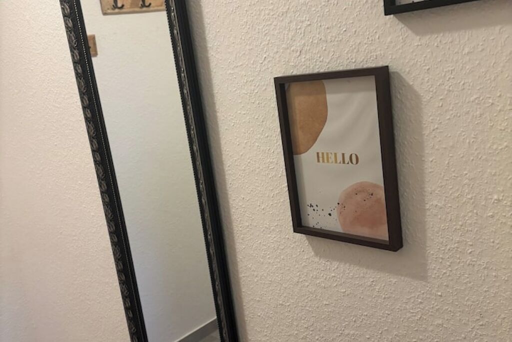 A framed artwork with the word "HELLO" on a textured wall.