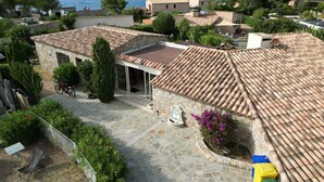Eine Villa im mediterranen Stil mit einer Steinterrasse, einer überdachten Sitzgruppe und Meerblick.