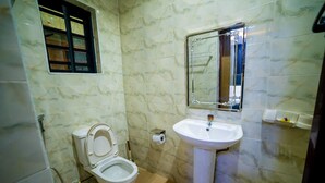 A bathroom with a toilet, sink, and mirror. - Evanluck Luxury Homes (Lagos)