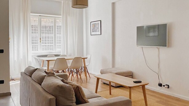 Een moderne woonkamer met een bank, salontafel en televisie.