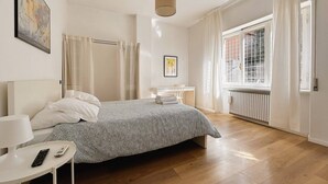 Een moderne slaapkamer met een bed, bureau en raam.