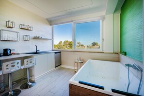 Een koelkast, een waterkoker, kookgerei, borden en bestek