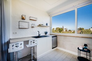 Een koelkast, een waterkoker, kookgerei, borden en bestek