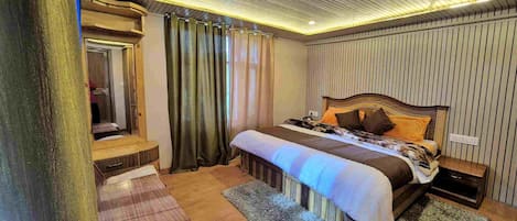 A bedroom with a wooden bed, a bedside table, a mirror, and a window with curtains.