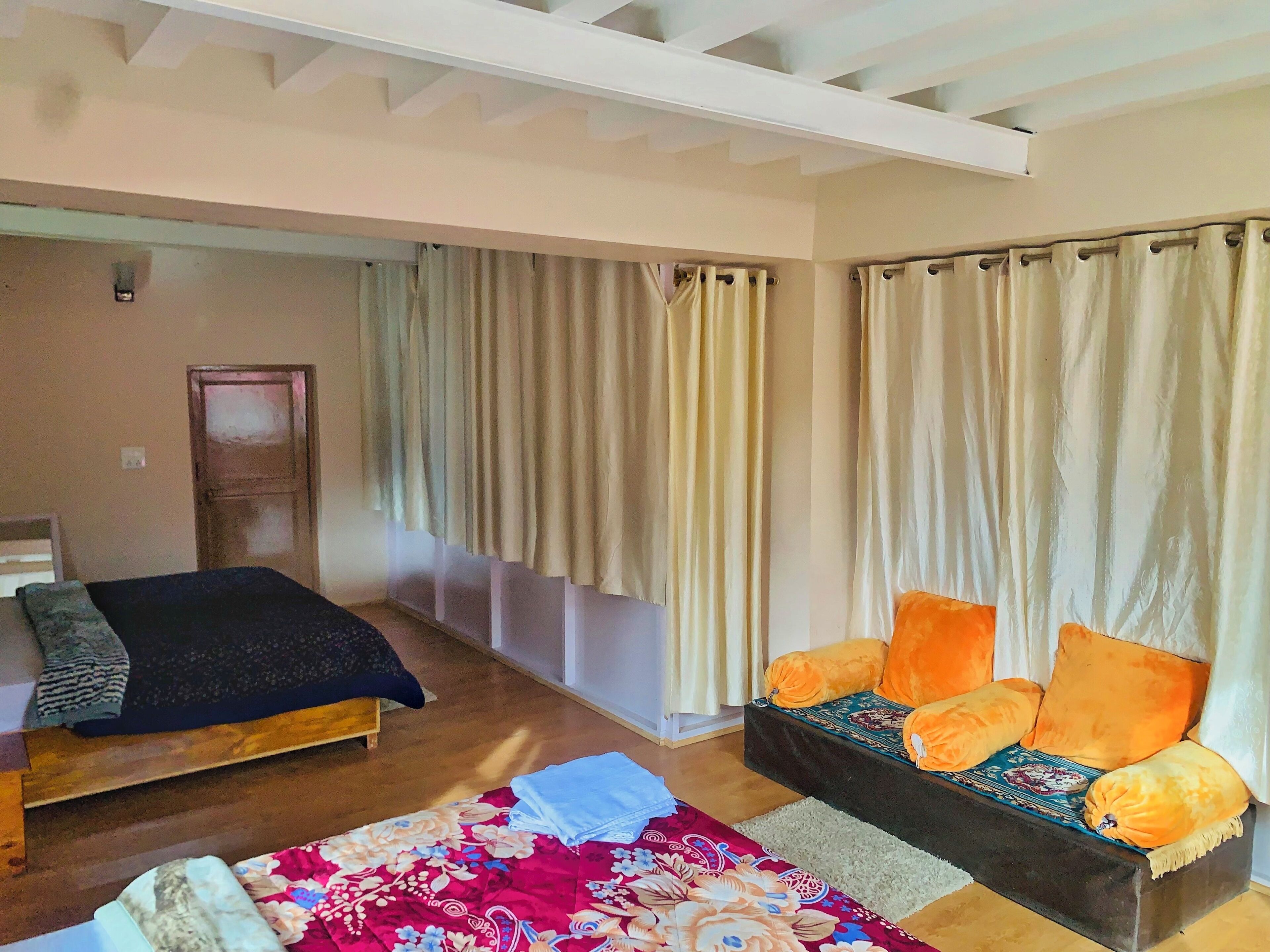 A room with a bed, a sofa, and curtains.