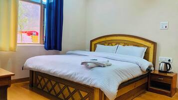 Una cama bien hecha con sábanas blancas, cabecera de madera y mesita de noche con tetera.
