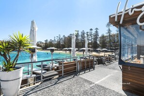 A seaside terrace with outdoor seating, umbrellas, and a pool. - MANLY - CLIF2 - Cliff Street - Manly beachside escape (Manly)