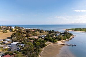 A coastal residential area with houses, a beach, and a pier. - Joeys Place- Waterfront| Views| Sunsets @Freycinet (Coles Bay)