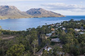 A coastal residential area with houses, a road, and a mountain in the background. - Freycinet Haven! Minutes to Wineglass Bay; Sunsets (Coles Bay)