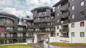 Un immeuble moderne à plusieurs étages, doté de balcons et d’une galerie couverte.