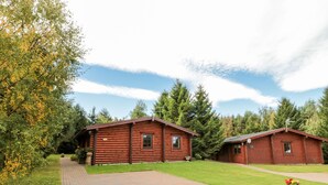 A log cabin resort with two cabins, paved pathways, and a well-maintained lawn. - Little Bears Hideaway @ 23 Lakeside (Morpeth)