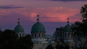 A view of three domed buildings with crosses on top, likely churches, set against a twilight sky. - Daisy Hotel (Addis Ababa)