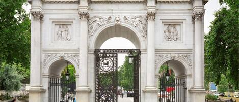A large, ornate stone archway with intricate carvings and a central black gate.