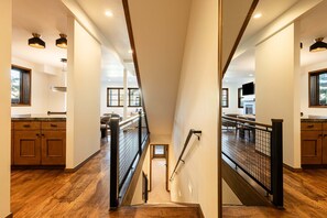 Ein modernes Interieur mit einer Holztreppe, einer Küchenzeile und Blick auf den oberen Stock.
