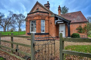 A brick building with a white door and a sign reading "South Lodge." - South Lodge at Longford (Longford)