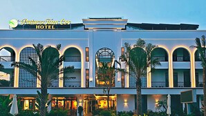 A hotel with a modern facade, arched windows, and a well-lit entrance. - Pataco Tam Coc Hotel (Nam Hoa Lu)