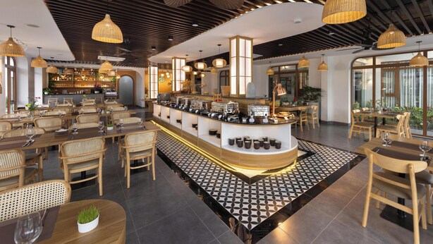 A modern restaurant with a central bar, wooden furniture, and pendant lighting. - Pataco Tam Coc Hotel (Nam Hoa Lu)