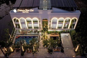 L’extérieur de l’hôtel PatacoTam Coc, avec sa piscine, son espace de détente en plein air et ses panneaux solaires.