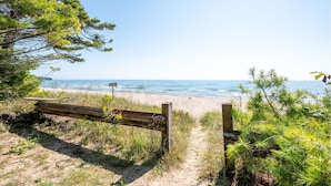 A beach path leading to the ocean with a wooden fence and greenery. - New in 2026! Glidden Pines -Beach Access -July/August Dates Still Avail! (Sturgeon Bay)