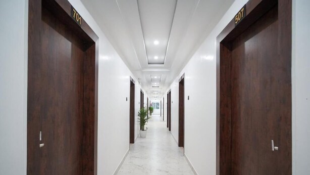 A long, narrow hallway with dark wooden doors numbered 701 and 507. - Royal Majestic Lodge  (Guwahati)
