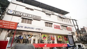 A multi-story building with various business signs including "LUCENT LAS" and "RUTI SUZUKI ARENA". - Royal Majestic Lodge  (Guwahati)