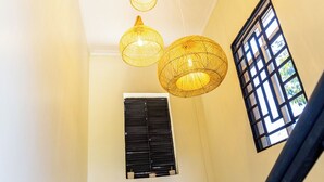 A staircase with black railings and a wall with three circular wall hangings and a window with black shutters. - Tadre House's (Arusha)