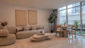 Una sala de estar moderna con sofá, mesa de centro y comedor.