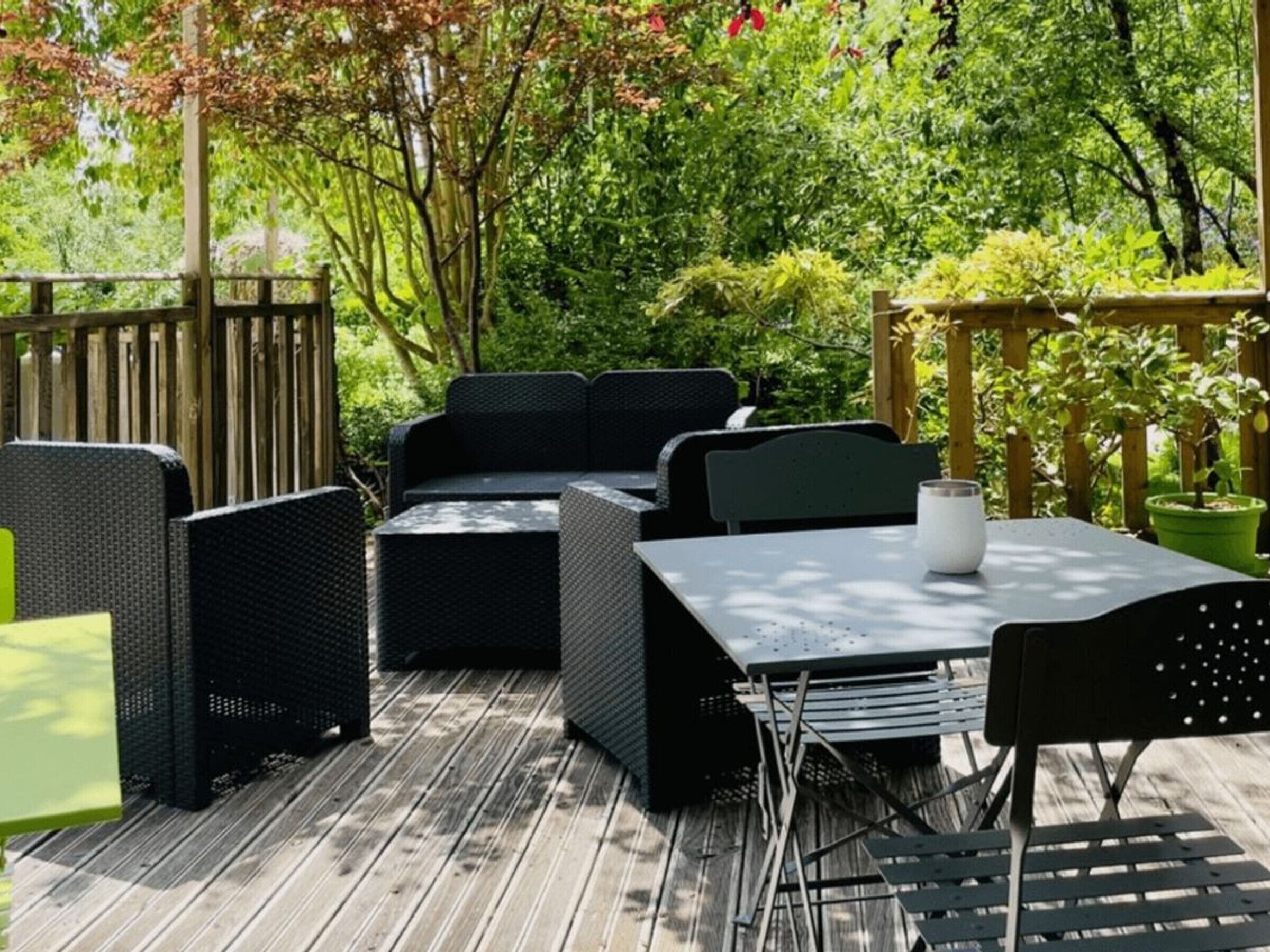 An outdoor patio with wicker furniture, a table, and chairs.