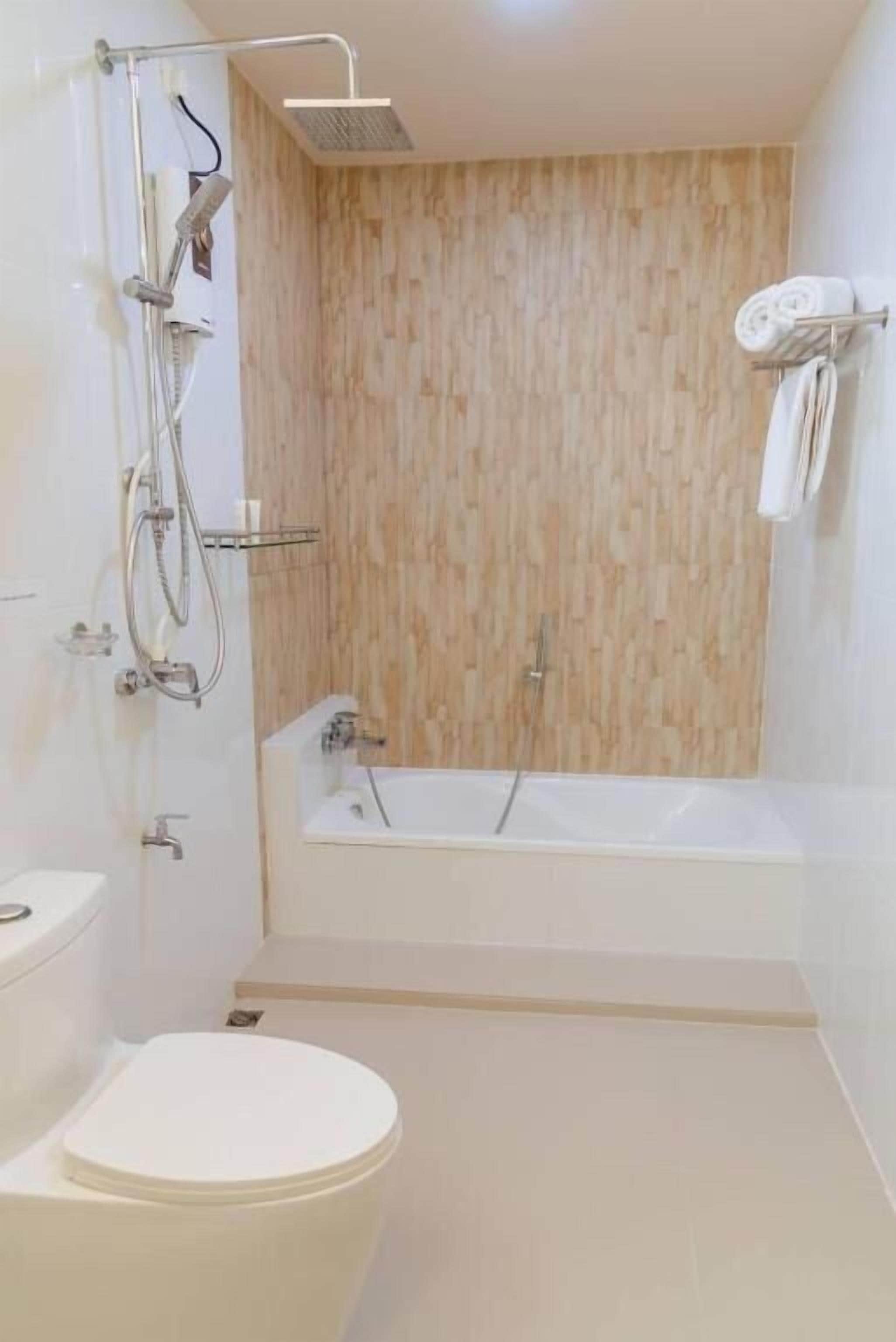 Une salle de bain moderne équipée d’une douche, de toilettes et d’une baignoire.
