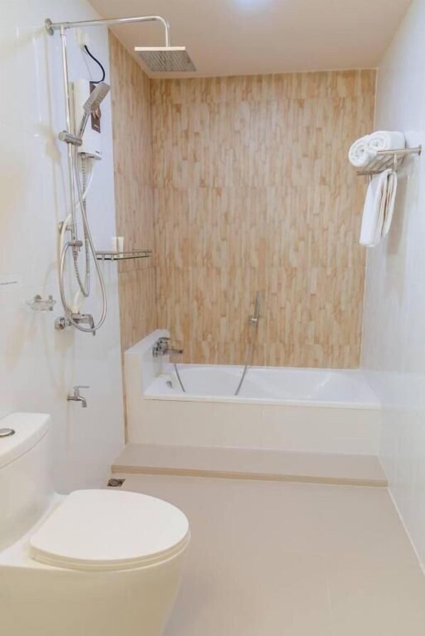Une salle de bain moderne équipée d’une douche, de toilettes et d’une baignoire.