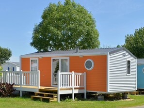 A mobile home with a porch, a small deck, and a window. - Mobile home with terrace, 5 people, Saint-Jean-de-Monts (Saint-Jean-de-Monts)