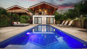 A modern villa with a swimming pool, a covered outdoor seating area, and a lush garden. - Villa Bernard - luxurious home in Tamarindo, walking distance to the beach& town (Tamarindo)