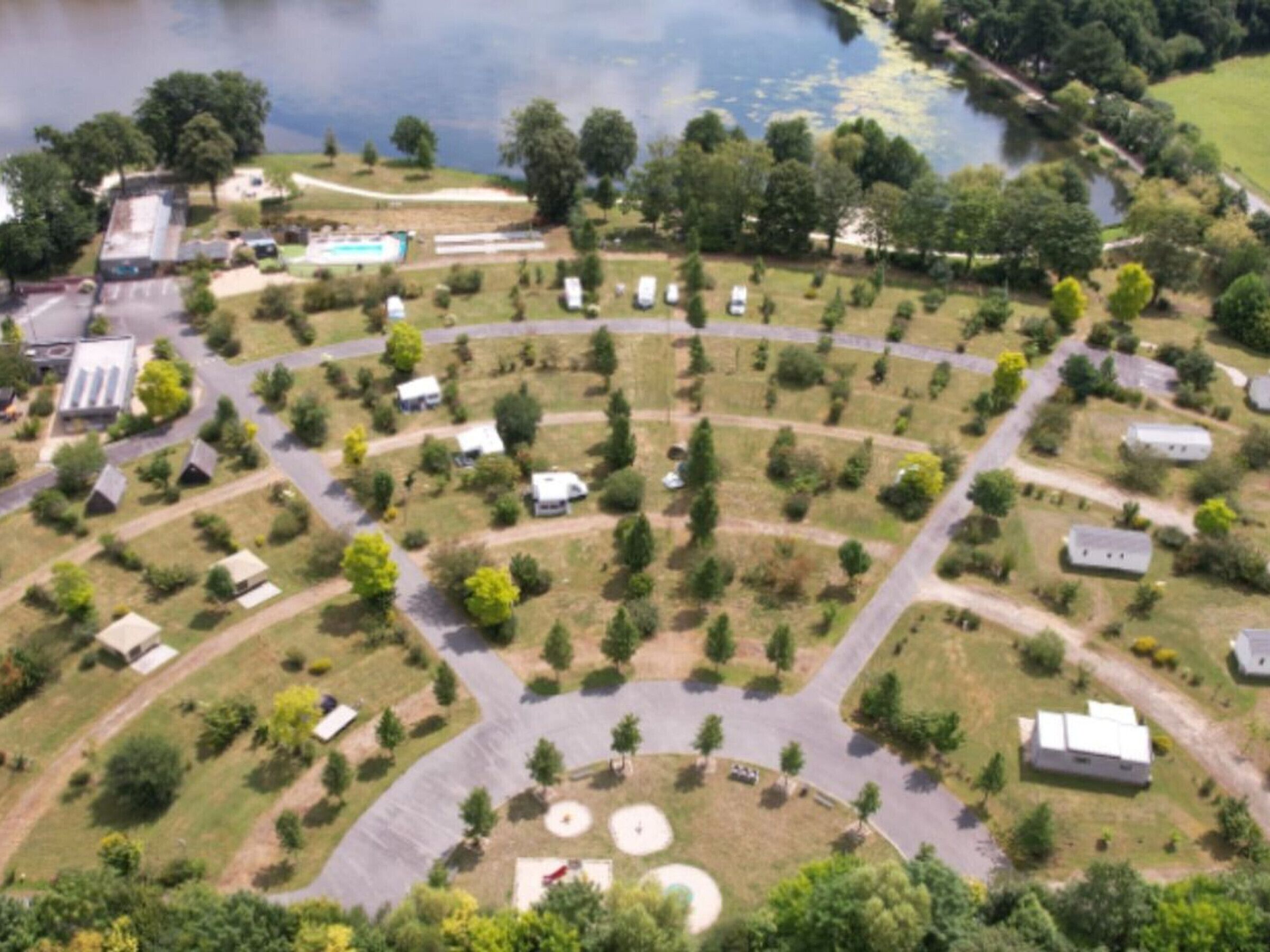 Vista aérea de una zona residencial con casas, carreteras y una masa de agua.