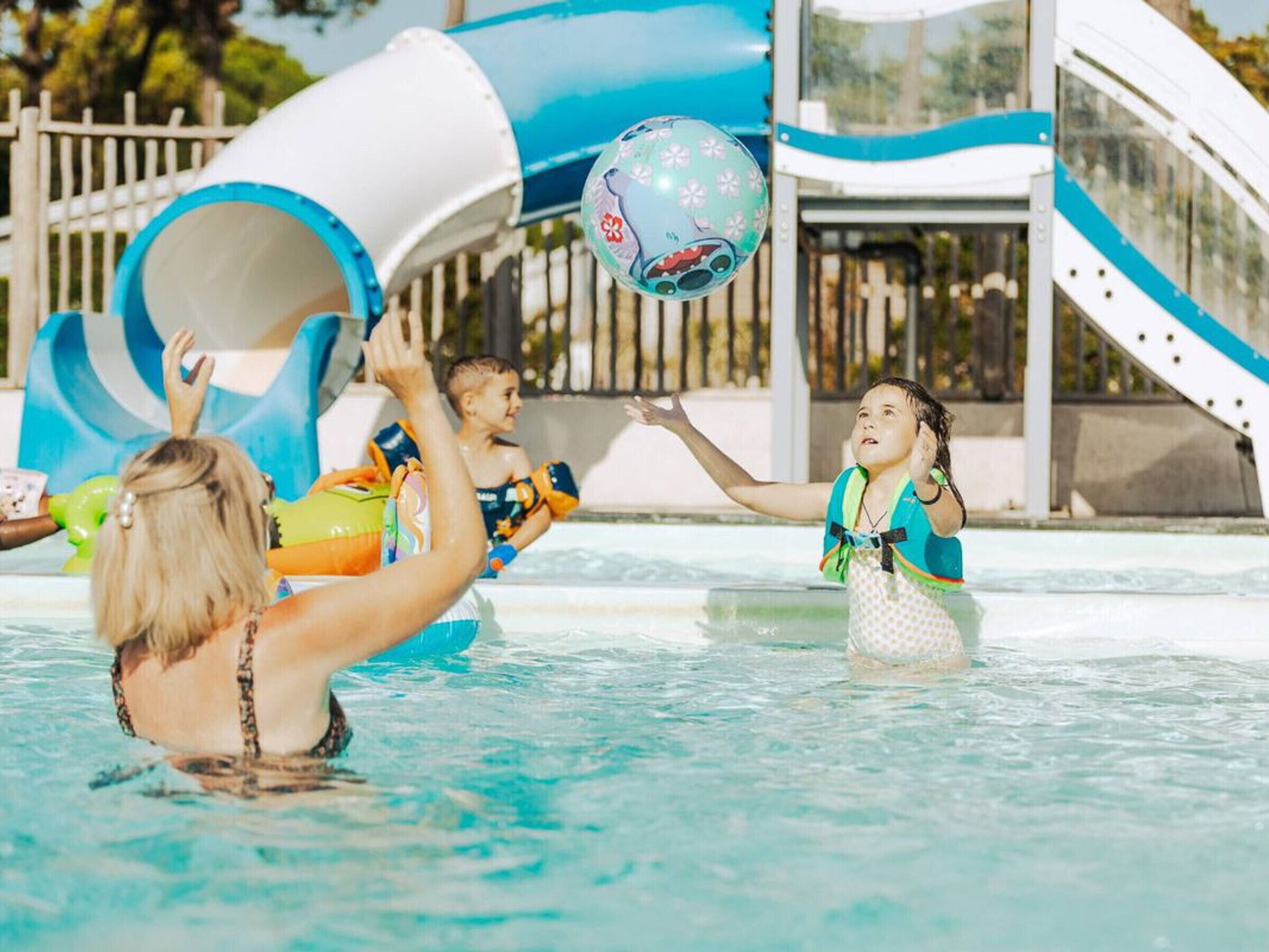 Une piscine avec un toboggan et un espace de jeux.
