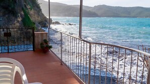A balcony with a view of the ocean and rocky coastline. - Apartment Gabbiana Elba Island (Portoferraio)
