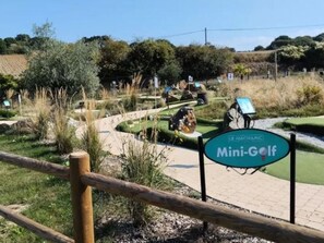 Ein Mini-Golf-Platz mit einem Schild, das angibt, dass er zu Le Parcours gehört.