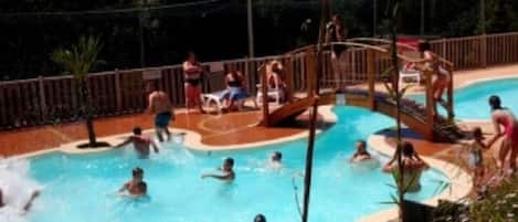 A swimming pool with multiple lanes and a water slide.