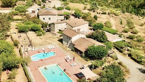 Eine Villa mit Swimmingpool, umgeben von üppiger Vegetation und terrassierten Feldern.