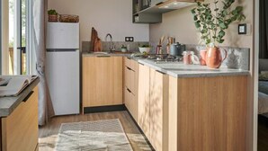 Una cocina moderna con armarios de madera, horno empotrado y encimera con varios objetos.