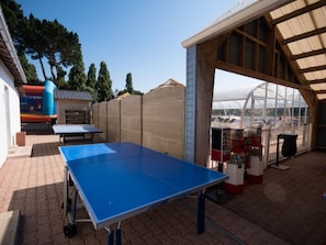 An outdoor area with a ping pong table, a small building, and a greenhouse structure. - Mobile home with terrace in Binic for 4 people (Binic)