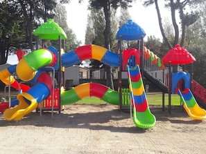 Ein Spielplatz mit mehreren Rutschen und Klettergerüsten.
