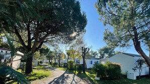 Ett bostadsområde med enplanshus, en asfalterad uppfart och omgivande grönska.