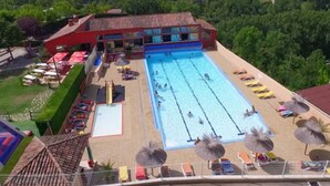 A swimming pool with multiple lanes, sun loungers, and umbrellas. - Mobile Home with Terrace - 3 Bedrooms, Sleeps 6 (Saint-Rome-de-Tarn)