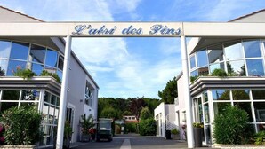 A building entrance with a sign reading 'L'Abri des Pins' and a vehicle parked in front. - Cozy chalet with terrace in Saint-Jean-de-Monts (Saint-Jean-de-Monts)