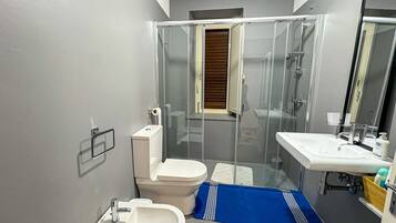 Ein kleines Badezimmer mit Toilette, Bidet und Waschbecken.