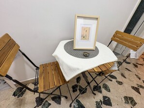 A small table with a framed picture, two wooden chairs, and a patterned floor. - B&B StudioArcodia - Camera Matrimoniale (San Marco D`alunzio)