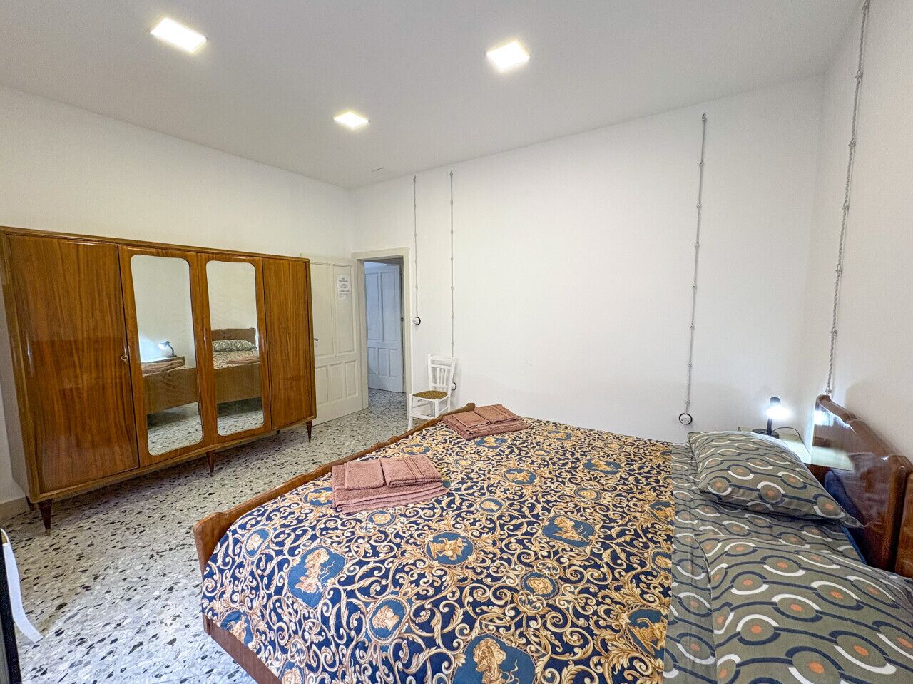 Ein Schlafzimmer mit einem Bett, einem Kleiderschrank und einem Sessel.