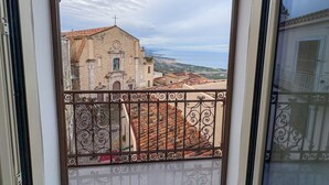 A balcony with wrought iron railings overlooking a historic building with a cross on top, set against a cloudy sky. - B&B StudioArcodia - Camera con Balcone (San Marco D`alunzio)