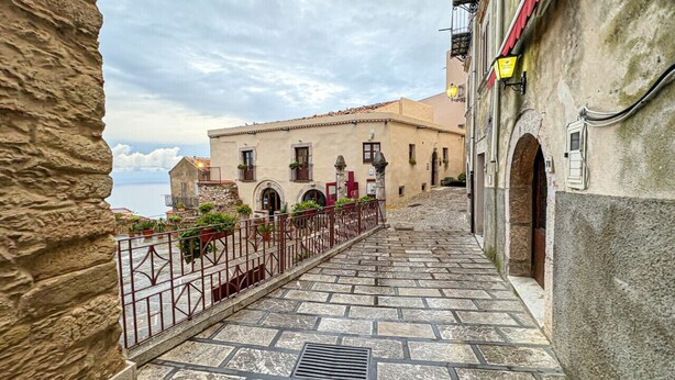 A stone staircase leading to a building with arched windows and a red railing. - B&B StudioArcodia - Camera con Balcone (San Marco D`alunzio)